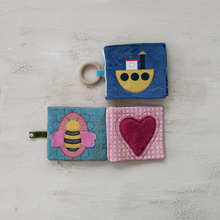 Load image into Gallery viewer, Two fabric books with a bee and heart design on a textured surface