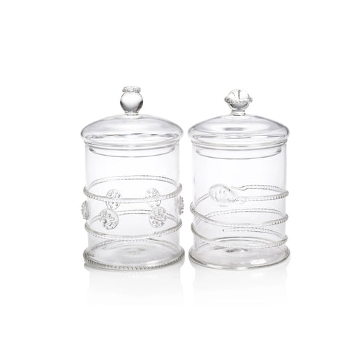 Two clear glass jars with decorative lids on a white background