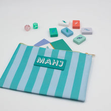 Load image into Gallery viewer, Teal and light blue striped Mahjong accessory bag with gold zipper and a teal rectangular patch with "MAHJ" on it, displayed with colorful Mahjong tiles, dice, and score cards on a white surface.