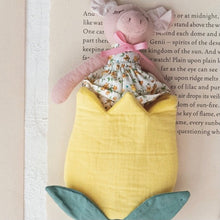 Load image into Gallery viewer, A pink pig plushie wearing a white floral dress in a yellow tulip bag on an opened book.