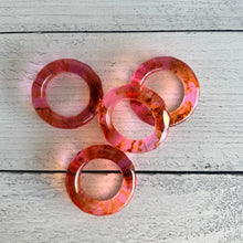 Load image into Gallery viewer, Set of pink and orange acrylic napkin rings on a wooden surface