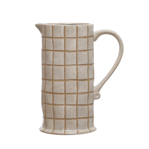 Beige ceramic pitcher with grid pattern on a white background.