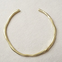 Load image into Gallery viewer, 14K gold double semi-matte plated brass choker necklace with a gently, uneven, organic shape displayed on a cream woven fabric surface.