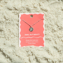 Load image into Gallery viewer, Sterling silver-dipped necklace featuring a small coral branch charm pendant and a chain with delicate beaded accents, displayed on a pink &quot;Small But Mighty&quot; Ocean Life Collection card by Lucky Feather with a white e wavy border, resting on white textured sand. 