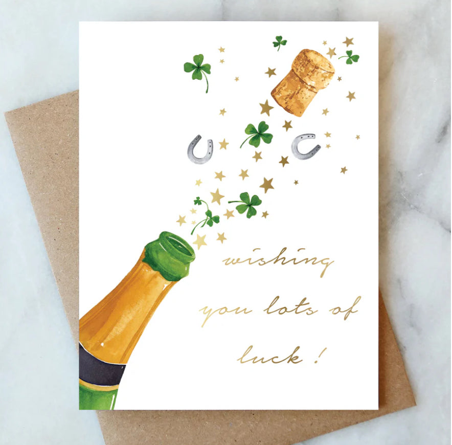 Greeting card with champagne bottle, clover leaves, horseshoe, and cork with 