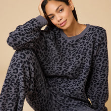 Load image into Gallery viewer, Person wearing a soft gray lounge set with a black leopard print pattern, displayed against a soft beige background. 