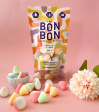 Load image into Gallery viewer, C'est Bon Bon Rainbow Bites gummies pouch with colorful abstract packaging, pastel cone shaped candies displayed in bowl and scattered on a pink background with pale pink flower.