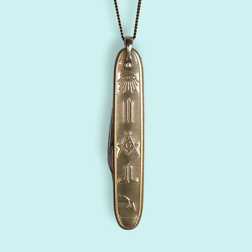 Pocket knife charm on a gold chain. Light blue background. 