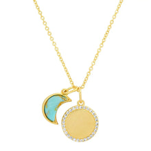 Load image into Gallery viewer, Gold-plated necklace with a layered crescent moon and round golden disc charm, accented with turquoise-toned enamel and clear crystal detailing, shown in close-up on a white background.