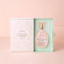 Load image into Gallery viewer, Snowdrop eau de parfum displayed with its decorative box, featuring a clear glass perfume bottle with a gold collar and pink transparent cap beside a mint green and pink patterned package on a powder pink background. 