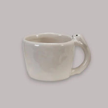 Load image into Gallery viewer, White ceramic mug with a handle shaped like a bunny on a light gray background