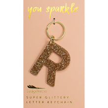 Load image into Gallery viewer, Gold glittery letter &quot;P&quot; keychain on a pink card with &quot;you sparkle&quot; in gold text, displayed against a white background.