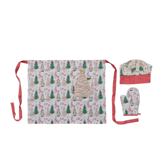 Kids holiday baking set including a Christmas tree print apron with red ties, a matching chef hat with a red base, and a matching oven mitt with red trim and a loop for hanging, displayed against a white background. 