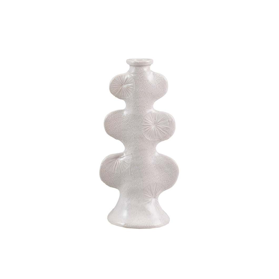 White ceramic taper candle holder  with an embossed design on a white background.