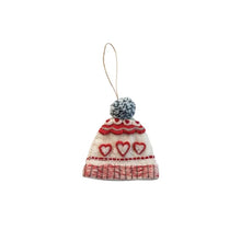 Load image into Gallery viewer, Wool beanie ornament with a blue and white pom-pom, cream and red base, and a red knit pattern featuring hearts and scallops. Ornament has a hanging loop and is displayed against a white background.  