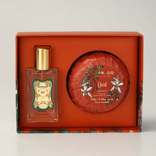 Load image into Gallery viewer, Granado Oud gift set with travel-size cologne bottle featuring decorative floral Oud label and gold cap beside round orange floral-wrapped Oud bar soap inside an orange presentation box. 