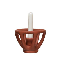 Load image into Gallery viewer, Stoneware Taper Holder, matte terracotta-colored stoneware taper candle holder with open sculptural design and white taper candle against white background. 