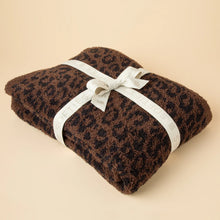 Load image into Gallery viewer, Folded brown and black leopard-patterned blanket tied with a white ribbon printed with &quot;SOFTIES&quot; in beige, displayed on a cream-colored surface. 