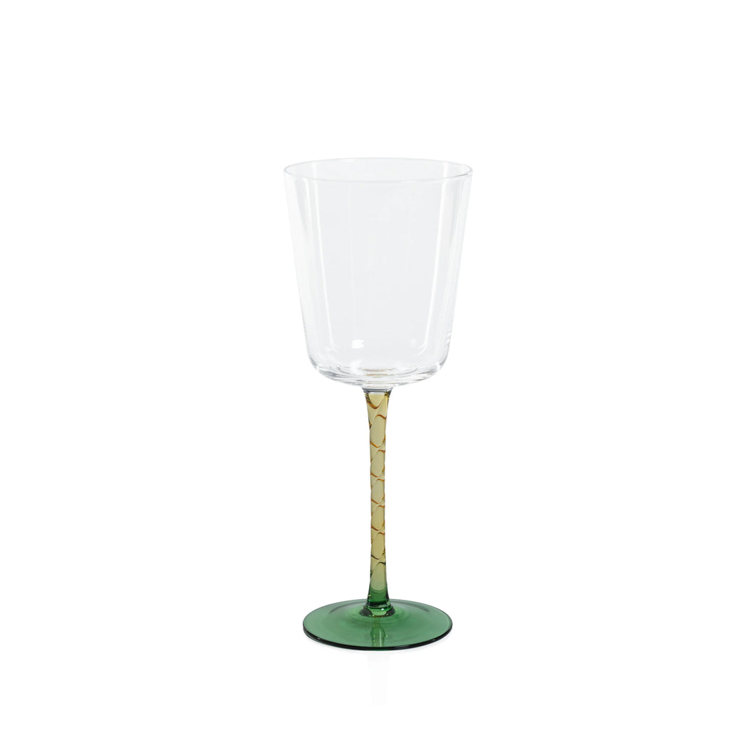 Clear red wine glass with an amber stem and a green circular base displayed on a white background. 