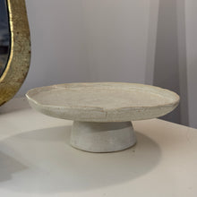 Load image into Gallery viewer, Cream-colored stoneware cake stand with an organic round shape on a white tabletop.