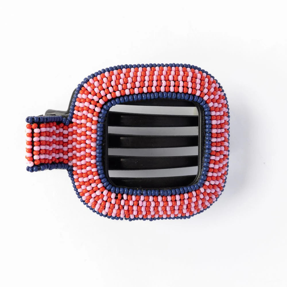 A red, pink, and navy beaded  hair clip on a white background.