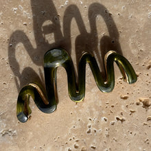 Load image into Gallery viewer, Forest green wavy claw clip with gold metal hardware displayed on a beige travertine surface with soft shadows. 
