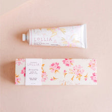 Load image into Gallery viewer, Floral Lollia hand cream tube beside its pink floral packaging on a pink background