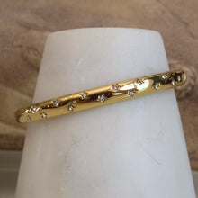 Load image into Gallery viewer, Gold bracelet with embedded diamonds on a white mannequin arm against a beige background