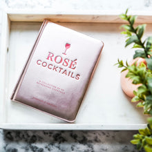 Load image into Gallery viewer, "Rosé Cocktails" recipe book with metallic pink cover displayed on a white tray. 