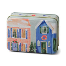 Load image into Gallery viewer, A rectangular shaped  tin with lid sitting on its side against a white background. Tin has a pink and blue house with pink wreaths above the doors .