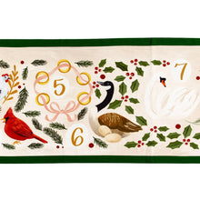 Load image into Gallery viewer, Close-up of the gold &quot;5&quot;, &quot;6&quot;, &quot;7&quot; illustrations from the 12 Days of Christmas table runner featuring gold rings, a black, white, and brown goose with eggs, and a white swan surrounded by green foliage on a white background with a green border. 