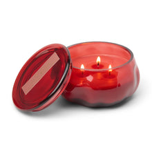 Load image into Gallery viewer, Red lit candle inside of a red glass container with its lid propped against it. Against a white background.