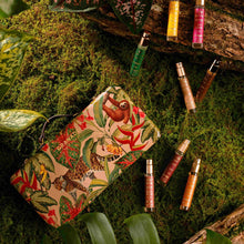 Load image into Gallery viewer, Granado Best-Sellers suitcase with tropical jungle illustration and animal motifs surrounded by eight assorted travel-size perfume sprays displayed on moss and greenery.