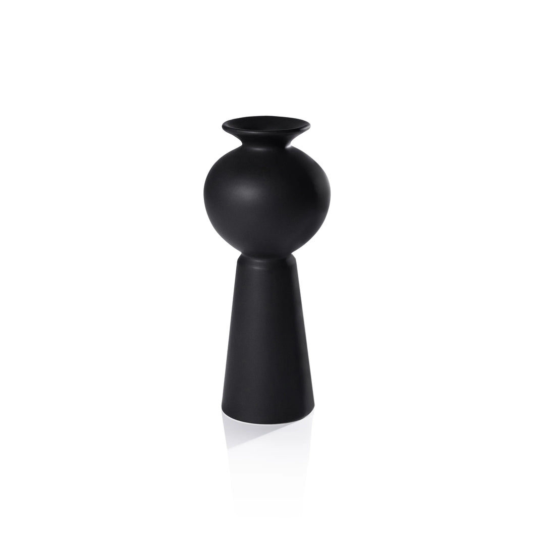 A matte black modern vase with sculptural silhouettes, placed against a wooden background.