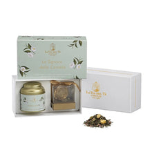 Load image into Gallery viewer, Tea gift set with a tea canister, an infuser, and loose tea leaves on a white background. Tea set is in a white box with a light green with white flowers and &quot;Le Signore delle Camelie&quot; text. 