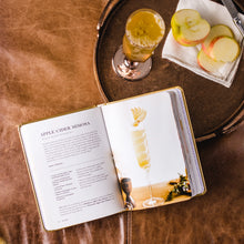 Load image into Gallery viewer, Open "BUBBLY" cocktail book showing an Apple Cider Mimosa recipe beside a sparkling drink and apple slices on a tray.