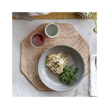 Load image into Gallery viewer, Gray bowl with pasta and greens on a hexagonal cotton jute placemat with two small cups with red liquid and clear liquid.