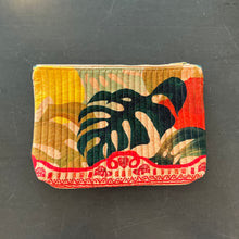 Load image into Gallery viewer, Quilted velvet zip pouch featuring a multicolor exotic palm leaf pattern with bottom red border trim and zipper closure, displayed on a dark surface. 