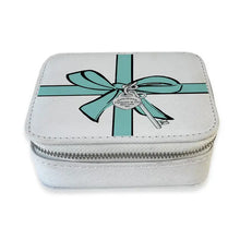 Load image into Gallery viewer, Light gray zippered travel pill box featuring a teal ribbon and bow with a silver spade and key charm illustration,, displayed on a white background. 