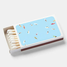 Load image into Gallery viewer, Matchbox with a light blue lid featuring small  surfer illustrations on a white background
