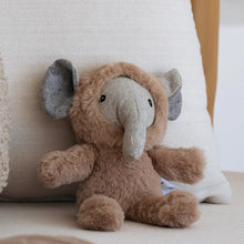 Load image into Gallery viewer, Mini caramel-colored plush elephant with a gray felted wool face, trunk, and inner ears, sitting upright on a cream textured cushion with a white pillow behind it.