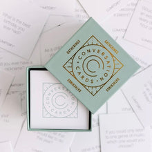 Load image into Gallery viewer, Blue box with a gold foil print that reads &quot;Conversation Cards&quot;. The box is opened and inside is a stack of white cards with a similar blue print. The box is on a background of the cards spread out. 