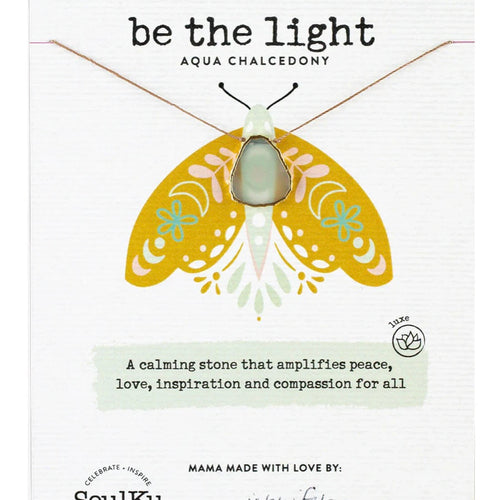 Grayish clear pendant on a gold chain , on a white card with a yellow butterfly design and 