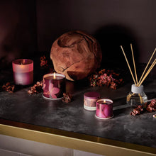 Load image into Gallery viewer, Decorative candles and diffuser on a dark marbled surface with a  large wooden ball and flowers.