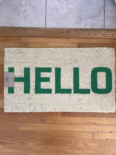 A rectangular white  doormat with the word 