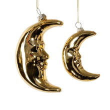 Load image into Gallery viewer, Gold Crescent Moon Ornaments, two reflective gold-tone blown glass crescent moons in large and small styles with sculpted facial profiles, suspended from thin gold cords against a white background.
