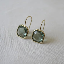 Load image into Gallery viewer, Gold-plated brass drop earrings featuring faceted octagon-cut green tourmaline stones set in thin bezel frames, displayed on a soft white textured surface. 