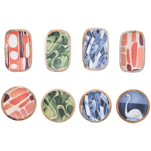 Set of eight decorative enamel dishes with various patterns  and a wooden bottom on a white background. Four rectangular shaped dishes on the  top in shades of pink and white, shades of green, shades of blue and white, and shades of pink and white. Bottom sets are in shades of pink and white, shades of green, shades of blue and white, and the last round dish is light and dark blue with a white swan.