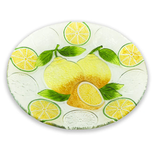 A clear glass plate with a pattern of yellow lemon slices and green leaves, on a white background.