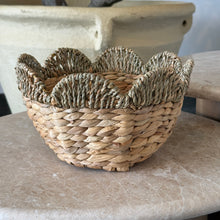 Load image into Gallery viewer, Handwoven seagrass bowl with scalloped rim displayed on round surface. 